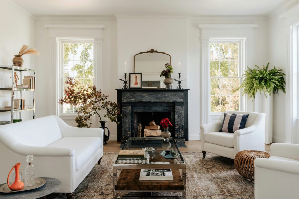 Symmetrical minimalist living room with black fireplace, white sofas, and curated decor