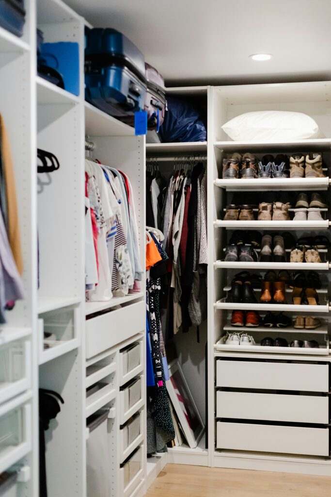 Modern organized closet interior featuring hanging rods for clothes, overhead shelving for storage bins, and a clean layout for small space organization